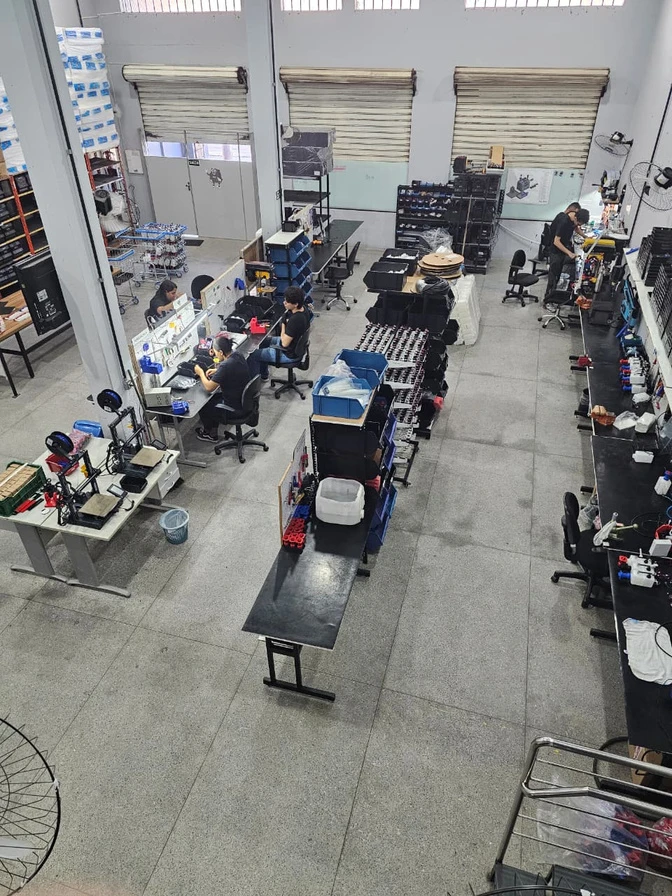 Vista da fábrica da Allcanci, com equipe e bancadas de produção